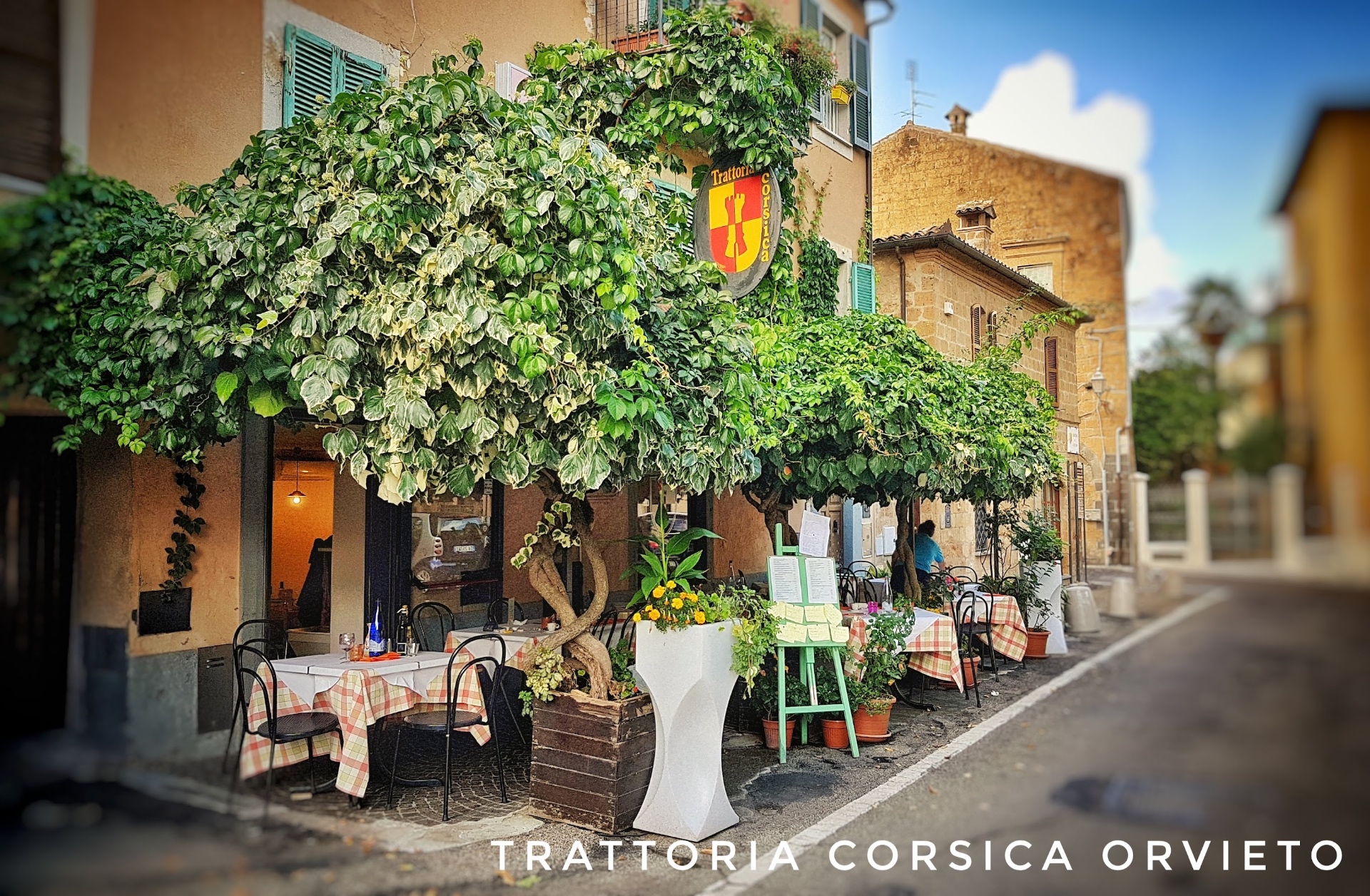 Facciata della trattoria al tramonto con insegna gialla e rossa