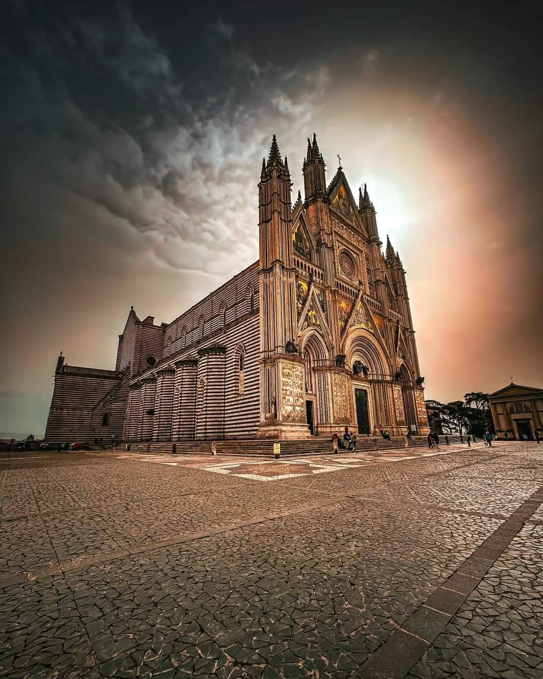 Facciata gotica del Duomo di Orvieto al tramonto con cielo infuocato